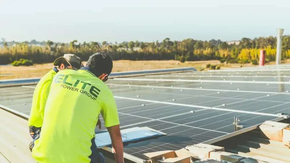 Técnicos inspecionando painéis solares em telhado